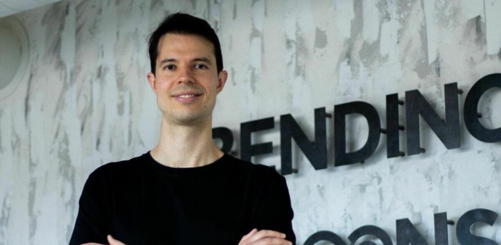 Dirigeant de Bending Spoons devant le logo de l’entreprise