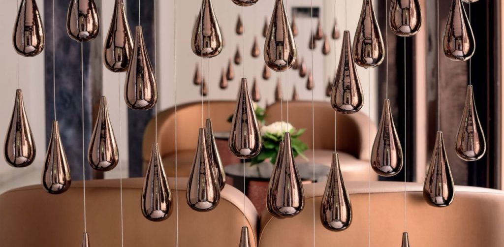 Espace intérieur d’un établissement Mövenpick avec suspensions décoratives métalliques