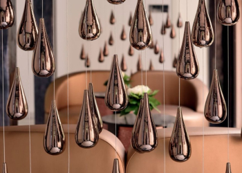 Espace intérieur d’un établissement Mövenpick avec suspensions décoratives métalliques