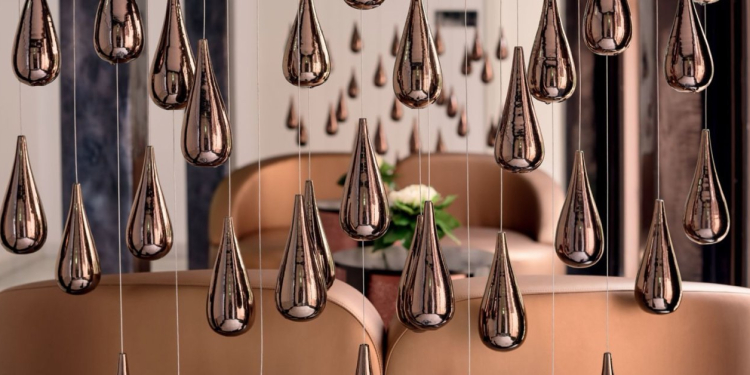 Espace intérieur d’un établissement Mövenpick avec suspensions décoratives métalliques