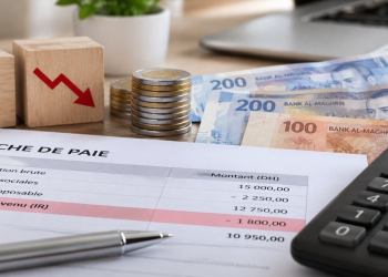 Fiche de paie, calculatrice et billets en dirhams illustrant la baisse de l'impôt sur le revenu
