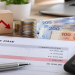 Fiche de paie, calculatrice et billets en dirhams illustrant la baisse de l'impôt sur le revenu